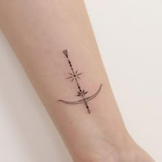 a small arrow tattoo on the wrist