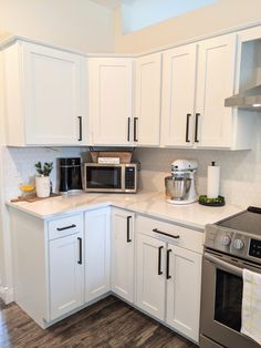 a kitchen with white cabinets and stainless steel appliances