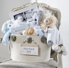 a baby boy gift basket sitting on top of a chair with stuffed animals in it