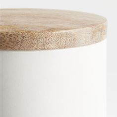 a close up of a white container with wood on the top and bottom, against a white background