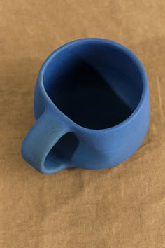 This 8 oz hand thrown stoneware coffee mug from Kati Von Lehman features an organic shaped body, and is finished with a unique and rich matte blue glaze. This mug is an eye-catching piece, that is the perfect artistic addition to any kitchen or office space. Fun Pottery, Clay Classes, Pottery Inspo, Hasami Porcelain, Tea Container, Farmhouse Pottery, Room Stuff, Ceramic Ideas, Kitchen Shop