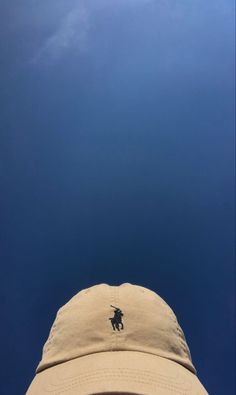 the back view of a hat with a polo logo on it, against a blue sky