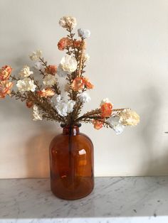 there is a vase with flowers in it sitting on the counter next to a wall