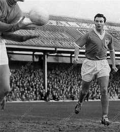 two men are playing soccer in front of an audience