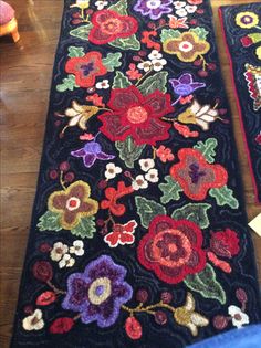 two rugs with flowers on them sitting on the floor next to each other,