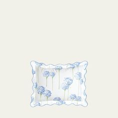 a blue and white pillow with dandelions on it