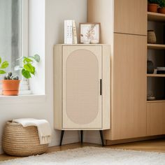 a room with a cabinet, potted plants and a rug on the floor in front of it