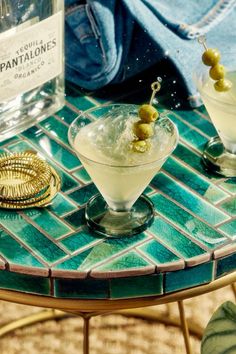 two martinis sitting on top of a glass table