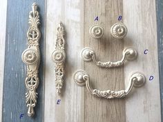 an assortment of ornate handles and knobs on a wooden surface with measurements for each handle