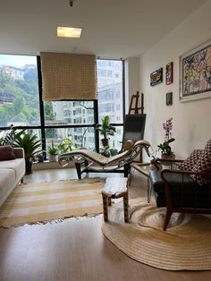 a living room filled with furniture next to a large window covered in windowsills