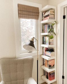 a white chair sitting next to a window filled with books