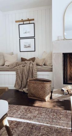 a living room filled with furniture and a fire place under a mirror on the wall