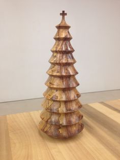 a wooden christmas tree sitting on top of a wooden floor