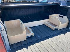 the back end of a pickup truck with wooden boxes in the trunk and seats folded down