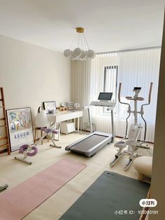 a room with various exercise equipment and yoga mats on the floor in front of a window