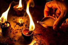 a person lighting candles on top of a metal pan with flames coming out of it