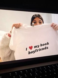 a woman holding up a t - shirt that says i love my book boyfriends