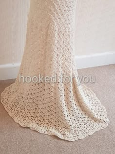 a crocheted dress is shown in front of a white wall and beige carpet