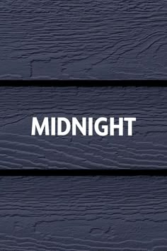 the word midnight written in white on dark blue painted wooden planks with text underneath it