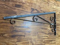 a wrought iron shelf bracket on a wood floor