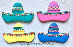 decorated cookies in the shape of boats and sombreros on a white background