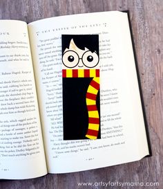 an open harry potter book with glasses and a striped scarf on the cover, sitting on a wooden table