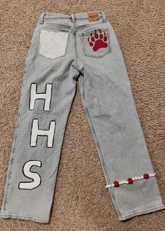 a pair of jeans with the word h s printed on it and a paw print