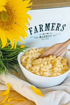 a bowl of macaroni and cheese next to a sunflower