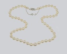 Fabulous Art Deco pearl necklace with diamond clasp The gorgeous pearls are individually hand knotted. They are a creamy ivory colour with a deep lustre. The pretty 9ct white gold diamond clasp is fitted with a safety chain This beautiful pearl necklace looks stunning when worn The necklace is 48cm (19" ) long 56 cultured pearls between 9.5mm - 6mm Clasp 14mm across Central diamond 2mm outer eight 15mm Push clasp with safety chain tests 9ct gold Necklace weighs 32 grams It dates the Art Deco per Pearl Necklace With Diamond, Ivory Colour, Necklace With Diamond, Beautiful Pearl Necklace, Safety Chain, Art Deco Period, Wedding Jewellery Necklace, Ivory Color, Wedding Necklace