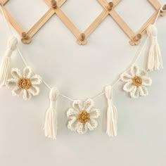 a crocheted flower and tassels hanging on a wall