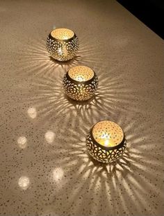 three tea lights sitting on top of a table next to each other in the shape of circles