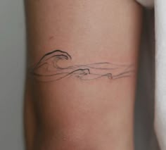 a woman's arm with a wave tattoo on the left side of her body