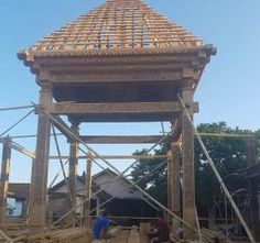 two men working on a wooden structure in the middle of construction work with scaffolding around it