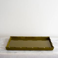 a green tray sitting on top of a white cloth covered table next to a wall