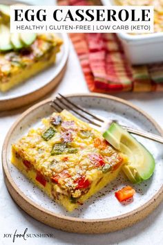 an egg casserole is on a plate with a fork and some sliced cucumbers