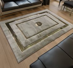 a living room with black leather couches and a rug on the floor in front of it