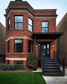 a large brick house with black steps leading up to the front door