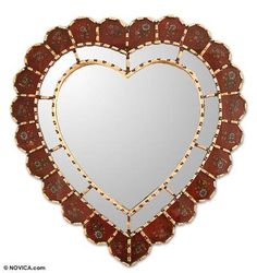 a heart shaped mirror hanging on the wall in front of a white background with red accents