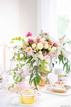 the table is set with flowers and fruit