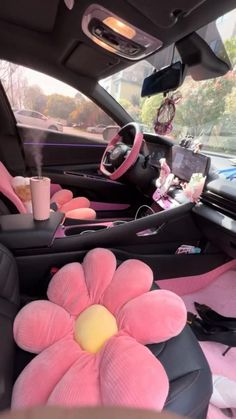 the interior of a car is decorated with pink flowers and black leather seats, along with an inflatable flower