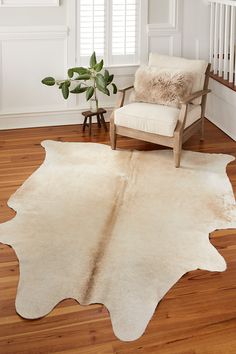 a living room with a chair and a cowhide rug