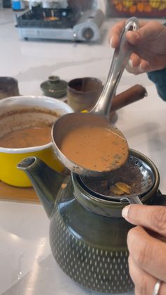 a person is stirring something in a pot on top of a saucer and spoon