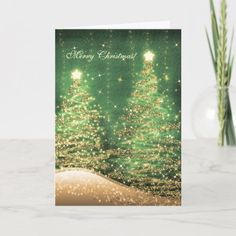 a green christmas card with gold glitter trees