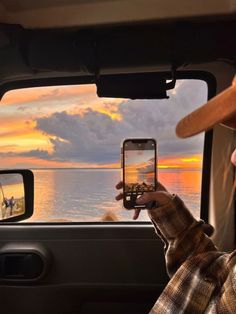 a man is taking a photo with his cell phone in the back seat of a truck