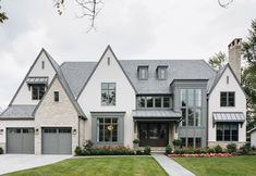 a large white house with lots of windows and grass in front of the door area