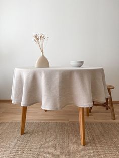 a table with a white cloth on it and a vase filled with flowers next to it