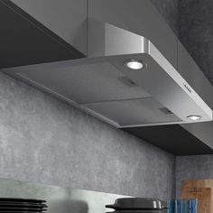 a stove top oven sitting inside of a kitchen under a ceiling light and pots on the counter