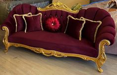 a red couch sitting on top of a hard wood floor