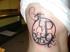 a woman's lower back tattoo with the letter d on her left ribcage