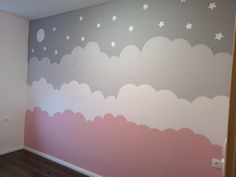 an empty room with painted clouds and stars on the wall